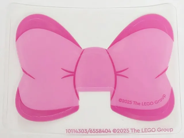 Plastic Bow with Magenta Edges and Creases on Dark Pink Background Pattern