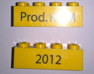 Brick 2 x 4 with Black '2012' and 'Prod. KOM' Pattern on Opposite Sides (Kornmarken Factory Tour)