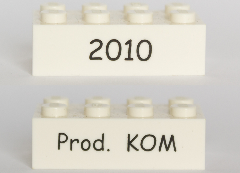 Brick 2 x 4 with Black '2010' and 'Prod. KOM' Pattern on Opposite Sides (Kornmarken Factory Tour)