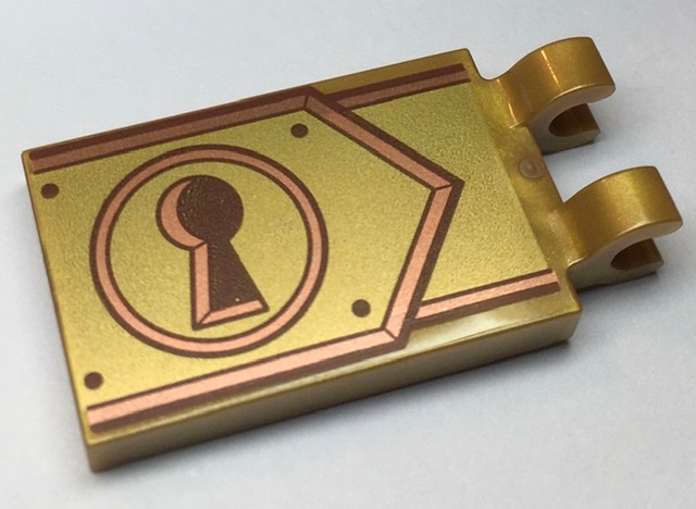 Tile, Modified 2 x 3 with 2 Clips with Reddish Brown Keyhole on Copper and Gold Clasp Pattern