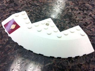 Brick, Round Corner 10 x 10 with Slope 33 Edge, Axle Hole, Facet Cutout with Jedi Logo on Dark Red Pattern Model Left (Sticker) - Set 9526