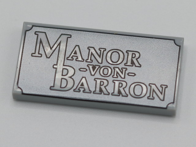 Tile 2 x 4 with 'MANOR -VON- BARRON' on Dark Silver Plaque Pattern