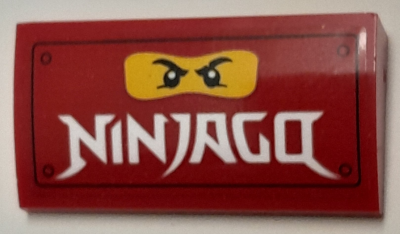 Slope, Curved 2 x 4 x 2/3 with Bottom Tubes with Yellow Minifigure Face and White 'NINJAGO' Pattern (Sticker) - Set 40429