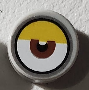 Tile, Round 1 x 1 with White Eye with Centered Reddish Brown Iris, Partially Closed Yellow Eyelid and Silver Outline Pattern