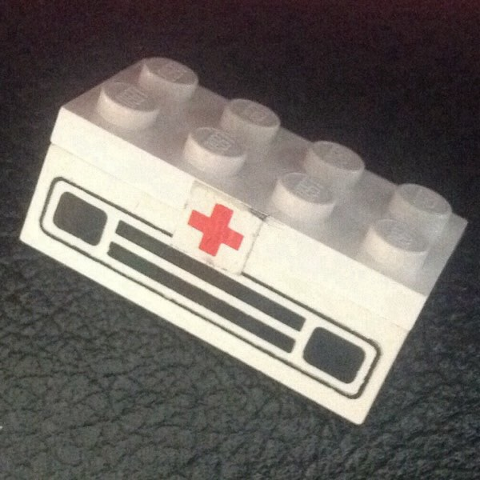 Stickered Assembly 4 x 2 x 1 1/3 with Small Red Cross Pattern (Sticker) - Set 386/770 - 1 Plate 2 x 4, 1 Brick 1 x 4 with Car Grille Black Pattern