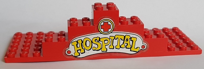 Stickered Assembly 16 x 6 x 3 1/3 with Red Cross and Yellow 'HOSPITAL' Pattern (Sticker) - Sets 137-1, 347-3 - 1 Red Plate 6 x 16, 2 Brick 2 x 2 without Inside Supports, 2 Brick 2 x 3 without Cross Supports, 2 Brick 2 x 4 without Cross Supports