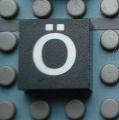 Modulex, Tile 2 x 2 (no Internal Supports) with White Lowercase Letter o with Diaeresis (ö) Pattern
