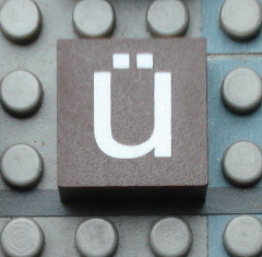 Modulex, Tile 2 x 2 (no Internal Supports) with White Lowercase Letter u with Diaeresis (ü) Pattern