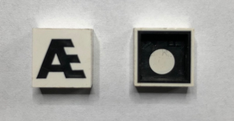 Modulex, Tile 2 x 2 with Black 'Æ' Pattern (Black internal lining with White dot)