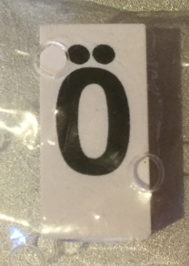 Tile, Modified 1 x 2 x 5/6 Stud Hole in End with Black Capital Letter O with Diaeresis (Ö) Pattern