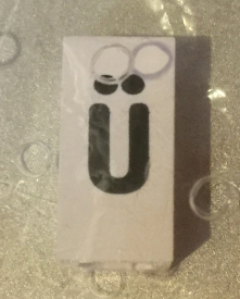 Tile, Modified 1 x 2 x 5/6 Stud Hole in End with Black Lowercase Letter u with Diaeresis (ü) Pattern