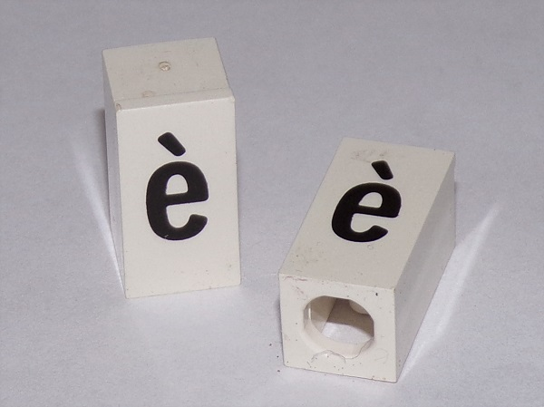 Tile, Modified 1 x 2 x 5/6 Stud Hole in End with Black Lowercase Letter e with Grave (è) Pattern