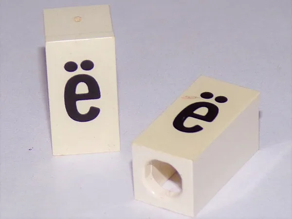 Tile, Modified 1 x 2 x 5/6 Stud Hole in End with Black Lowercase Letter e with Diaeresis (ë) Pattern