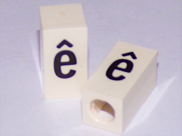 Tile, Modified 1 x 2 x 5/6 Stud Hole in End with Black Lowercase Letter e with Circumflex (ê) Pattern