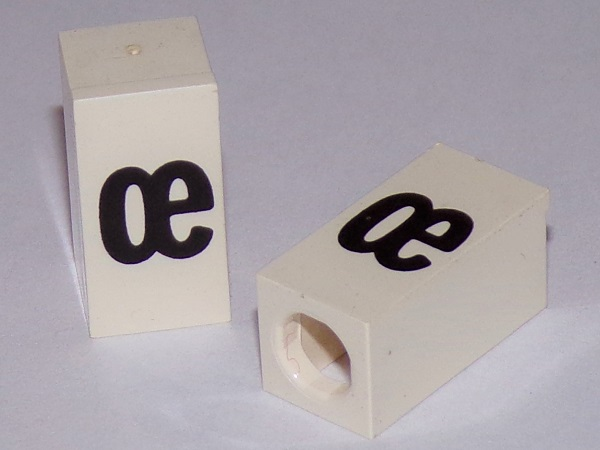 Tile, Modified 1 x 2 x 5/6 Stud Hole in End with Black Lowercase Ligature œ Pattern