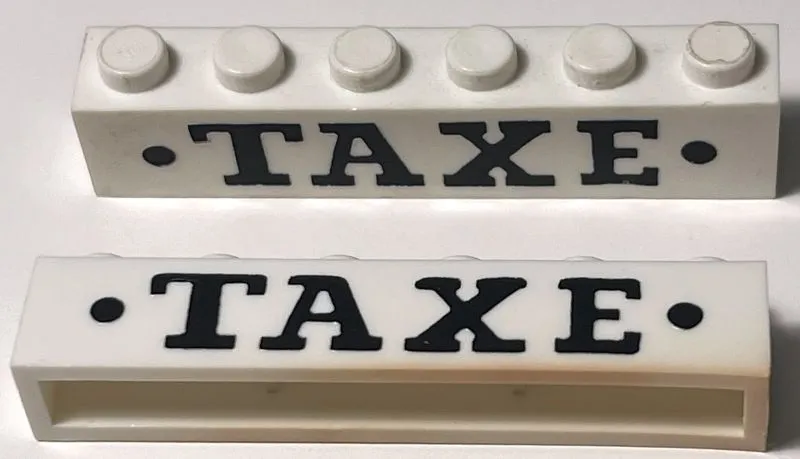 Brick 1 x 6 without Bottom Tubes with Cross Side Supports with Black 'TAXE' Serif Bold Large and Dots Pattern