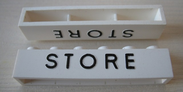 Brick 1 x 6 without Bottom Tubes with Cross Side Supports with Black 'STORE' Pattern