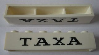 Brick 1 x 6 without Bottom Tubes with Cross Side Supports with Black 'TAXA' Serif Thin Pattern