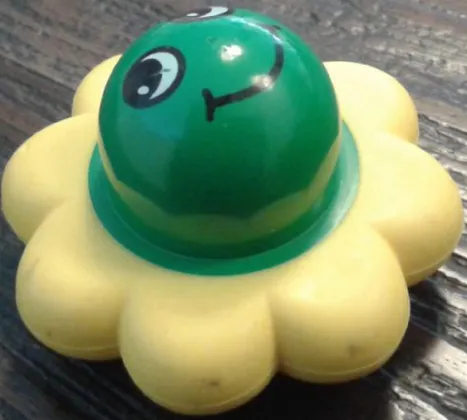 Primo Rattle Flower with 8 Yellow Petals and Smiley Face Pattern